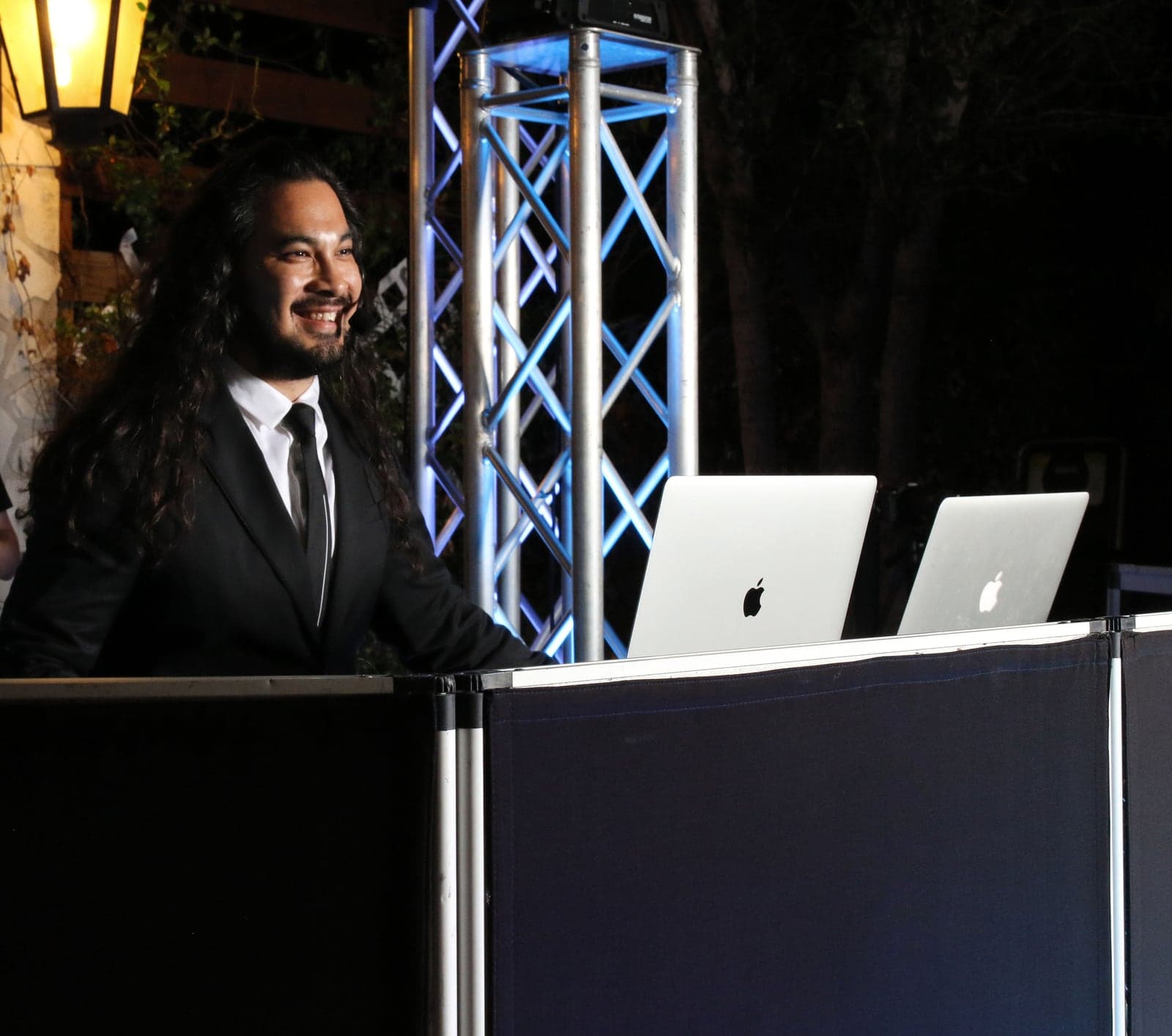 AB Event Productions DJ booth framed by truss lighting at a nighttime event