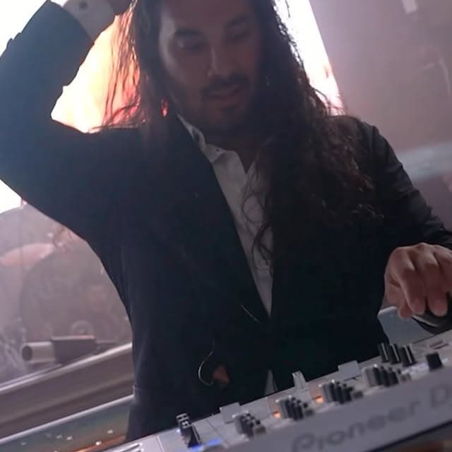 AB Event Productions DJ working a Pioneer mixer under stage lighting