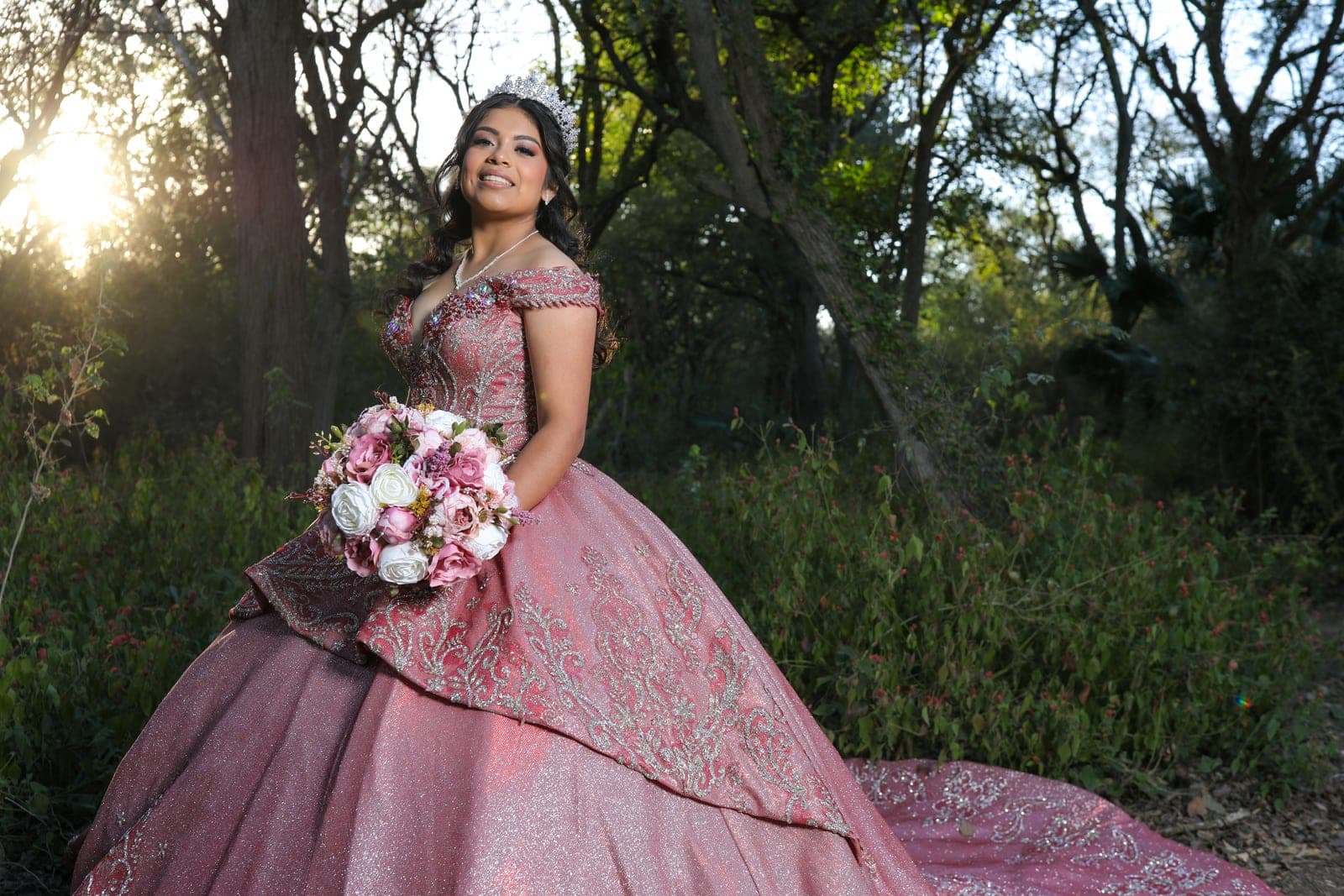 Quinceañera with her bouquet at sunset