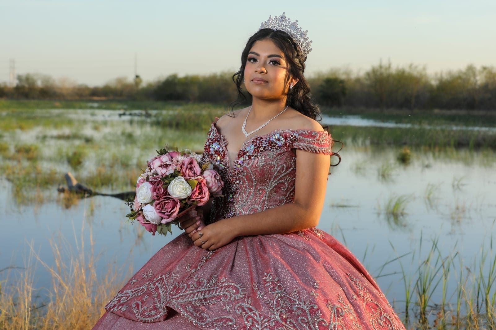 Quinceañera holding her bouquet by the water