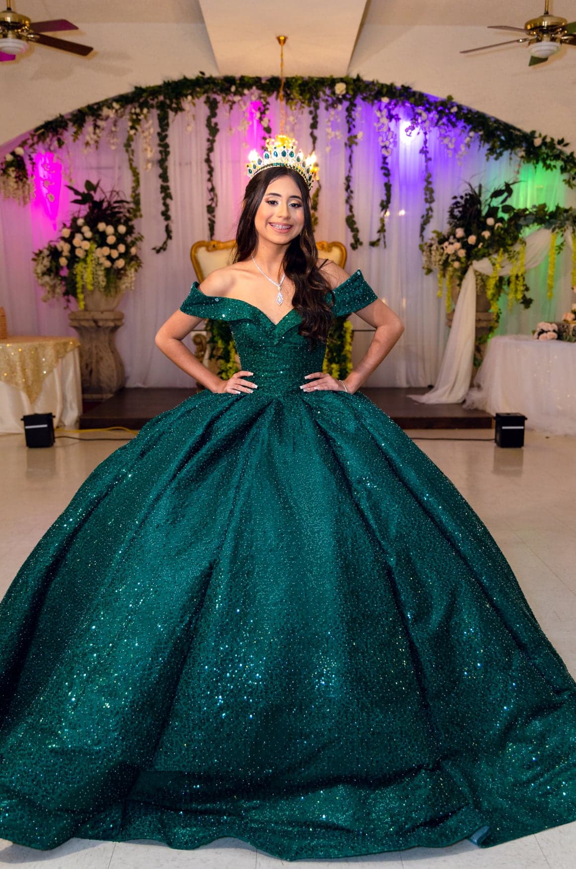 Quinceañera in an emerald-green ball gown at her reception