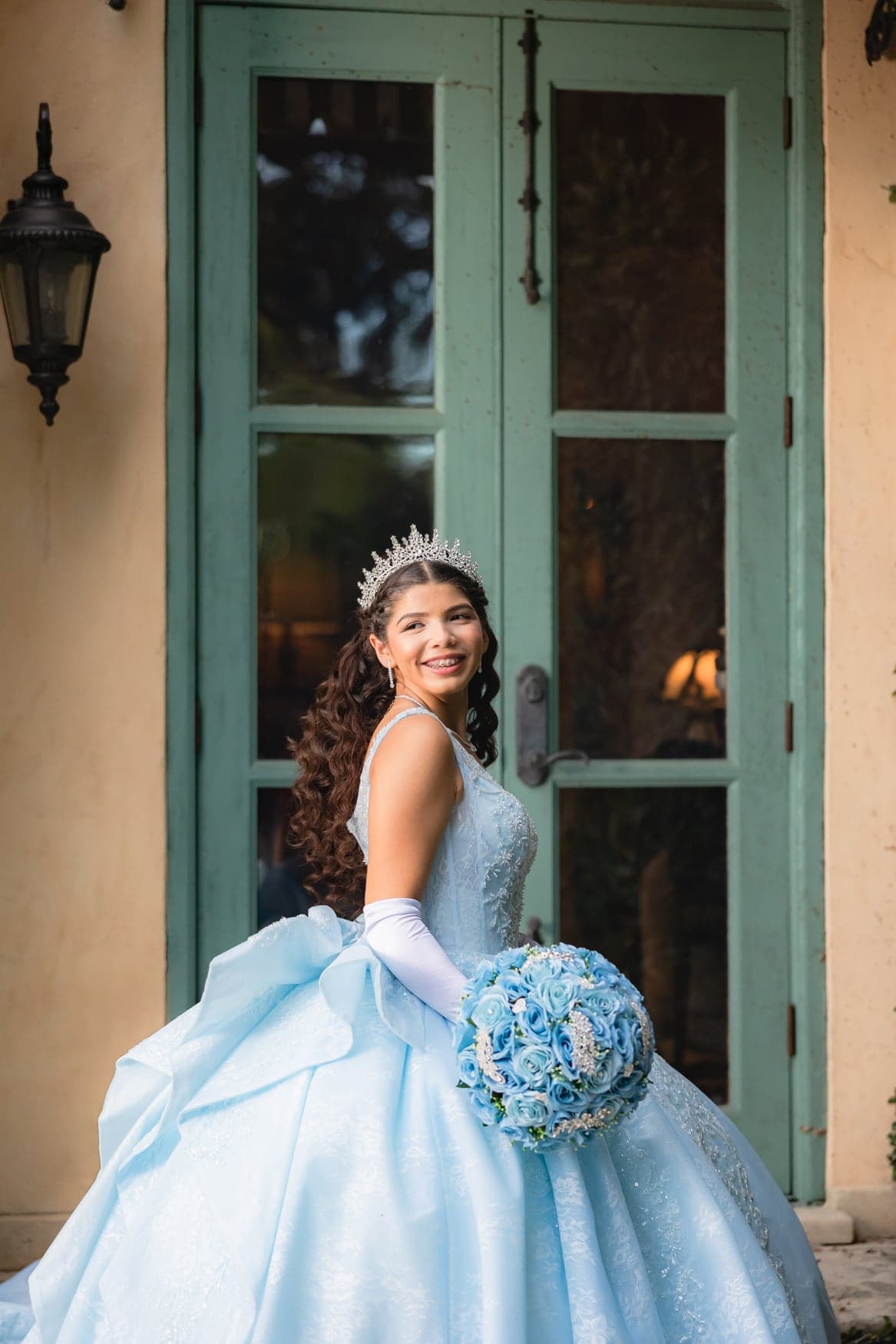 Quinceañera in a light-blue ball gown with her bouquet
