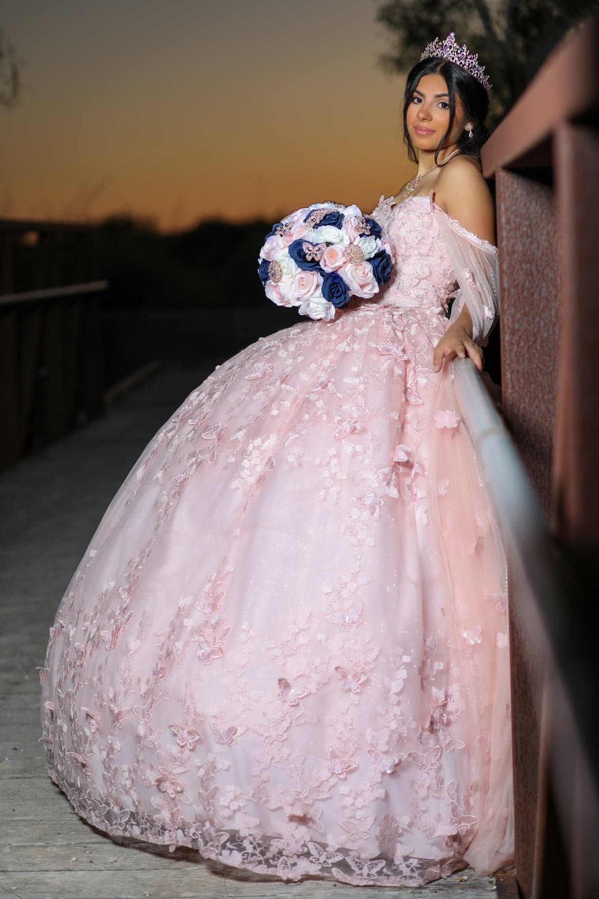 Quinceañera with her bouquet under blooming branches