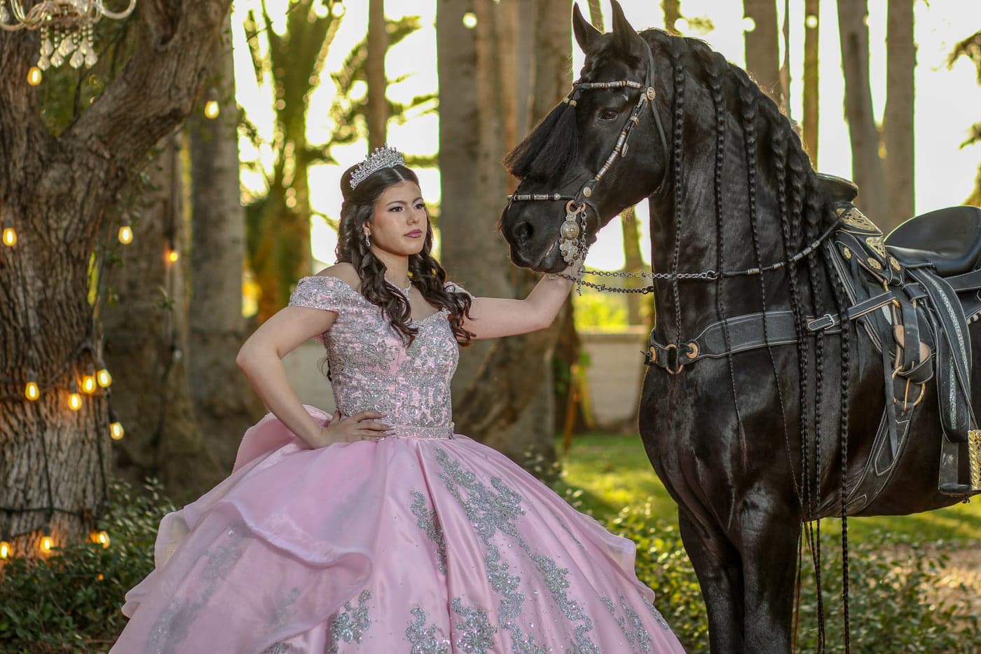Quinceañera in a rose gown beside a horse