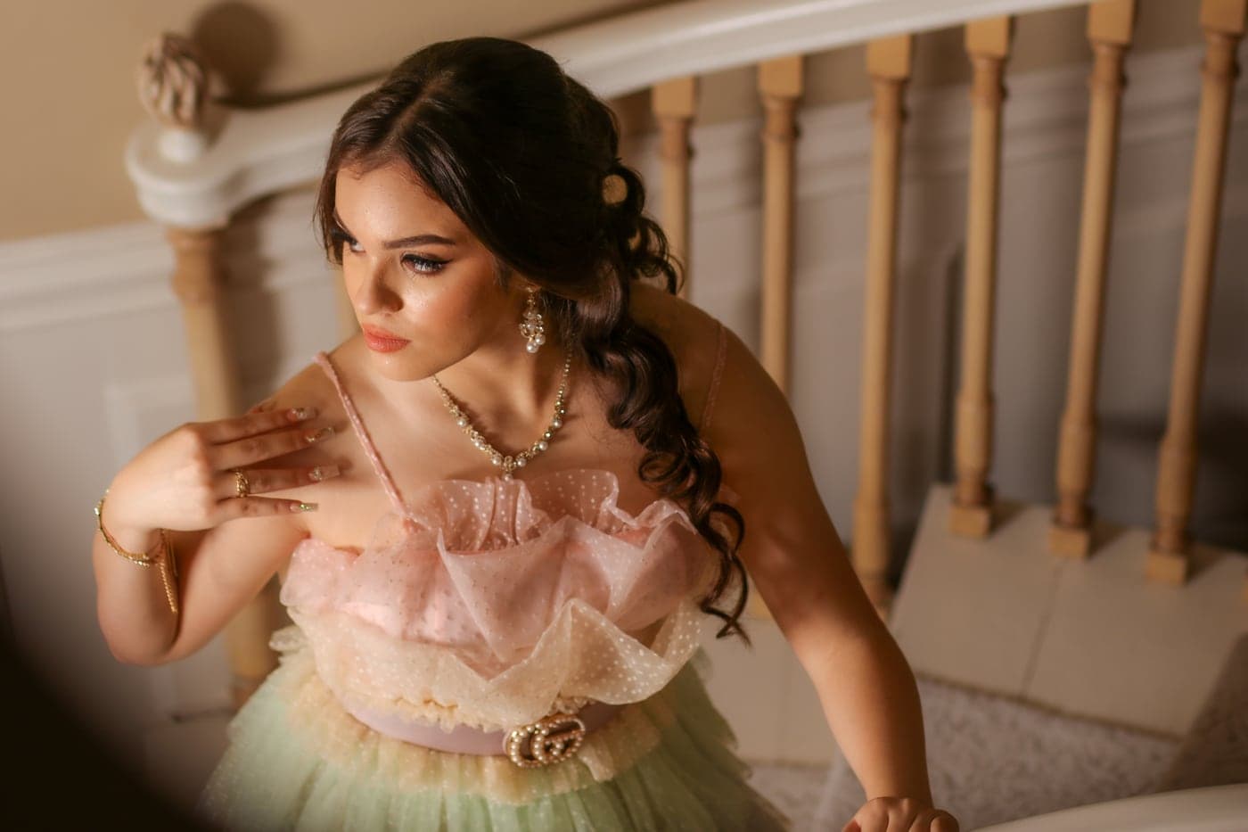Quinceañera in a champagne gown on a grand staircase