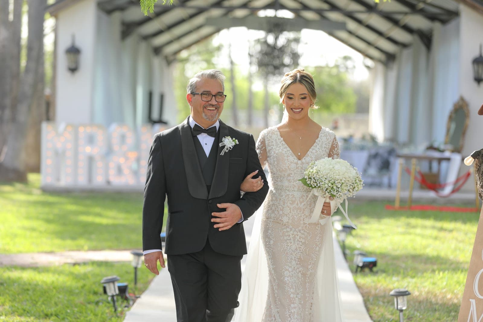 Father walking the bride down the outdoor aisle with MR & MRS marquee letters by AB Event Productions