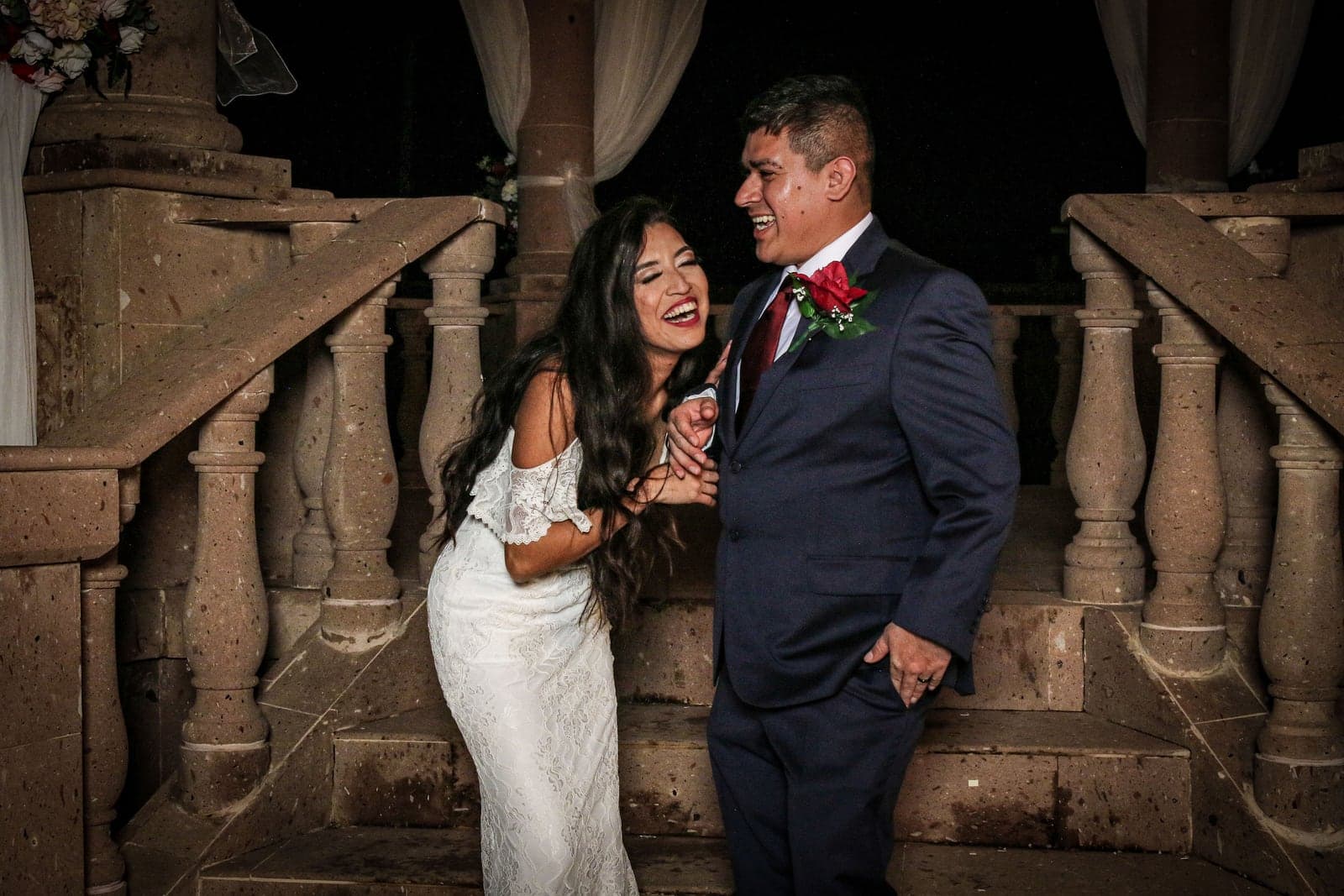 Bride and groom beside a grand staircase